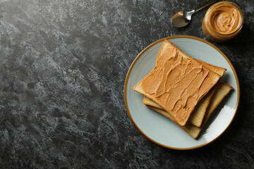 Concept of breakfast with peanut butter toast on black smokey table