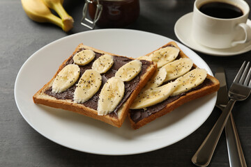 Concept of breakfast with toast with banana on wooden background