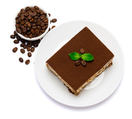 Traditional Italian Tiramisu square dessert portion on ceramic plate and coffee beans isolated on white background with clipping path