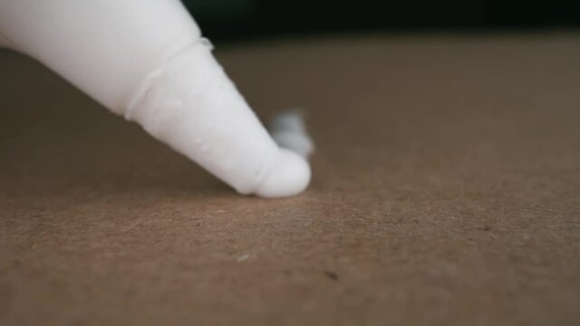 Man applies PVA glue to cardboard.&nbsp;Close-up.
