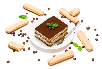 Traditional Italian Tiramisu square dessert portion on ceramic plate, savoiardi cookies and coffee beans isolated on white