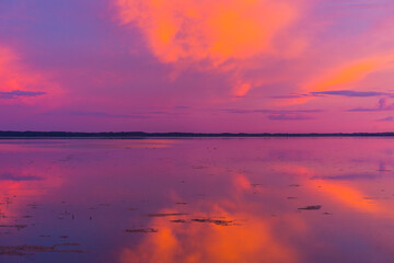 Beautiful colorful sunset over the lake summer landscape.