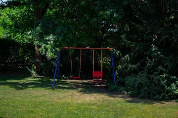 Fototapeta na wymiar A colorful children's swing in the garden on a summer's day