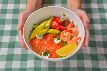 Fresh salad with seafoods, tomato and herbs. Red salmon, small shrimps, avocado, cherry tomatoes.