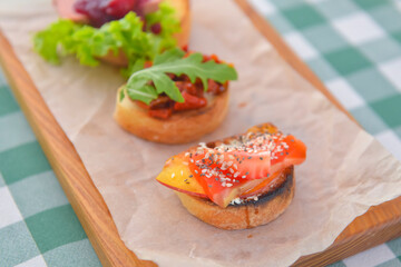 Juicy fresh Italian bruschetta over green plaid table cloth. Traditional Italian cuisine concept.