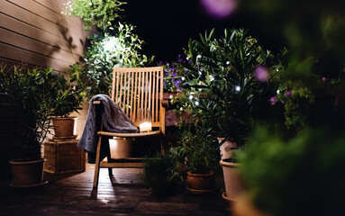 Candle on chair in the evening on terrace in summer.