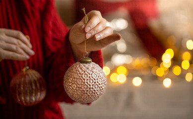 Beautiful Christmas toy in female hands close up on a blurred background copy space.