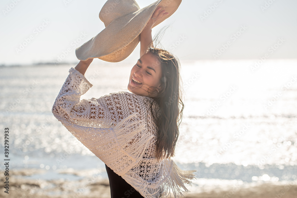 Sticker beautiful woman in hat and bathing suit on the beach.