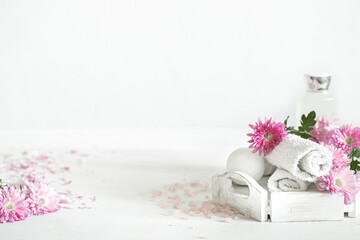 Spa composition with body care products and flowers on a light background copy space.