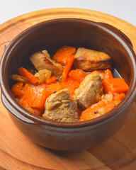 Meat pieces with pumpkin and tomato, mincemeat dish with fresh thyme.