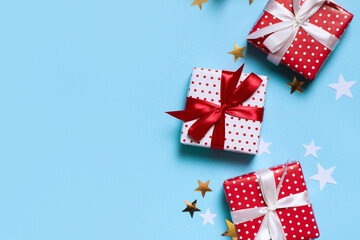Fototapeta na wymiar Red christmas gift box with confetti on blue background