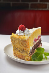 Raspberry cake. One piece of delicious fruit berry cake with vanilla frosting served on a white plate over white.