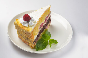 Raspberry cake. One piece of delicious fruit berry cake with vanilla frosting served on a white plate over white.