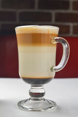 Cup of Lattee Coffee served with a plastic straw over white background. Delicious sweet coffee in a glass.