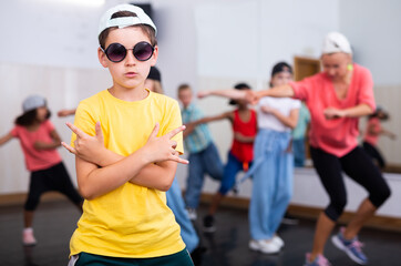 Fototapeta na wymiar Portrait of boy hip hop dancer exercising with friends at dance class