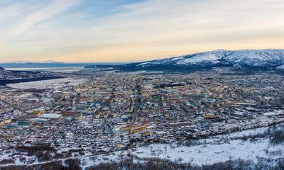 Fototapeta na wymiar Aerial view of the city of Magadan. Russian northern city located in the Far East in Asia. Winter city landscape. Top view of the streets and buildings. Magadan, Magadan region, Far East of Russia.