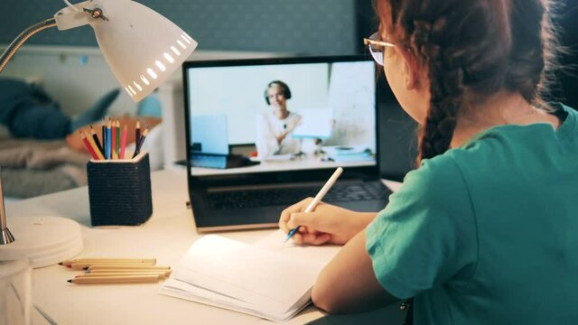 Schoolgirl studying hard during an online geometry class