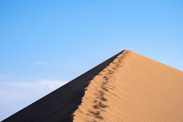 Fototapeta na wymiar Sand dunes with clouds backgorund. Natural landscape. Altyn-Emel singing dunes or barkhan. Altyn-emel national park in Kazakhstan. Tourism travel in Kazakhstan concept.