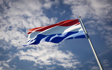 Netherlands national flag waving at sky background close-up.