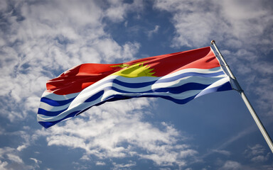 Kiribati national flag waving at sky background close-up.