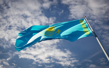Kazakhstan national flag waving at sky background close-up.