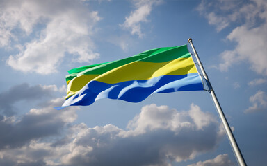 Gabon national flag waving at sky background close-up.