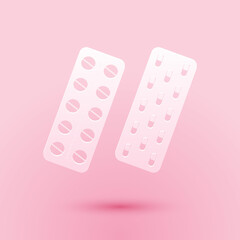 Paper cut Pills or capsules in blister package icon isolated on pink background. Tablets in package. Medications Accessory pharmacies and first aid kits. Paper art style. Vector.