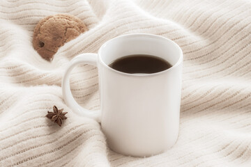 Obraz na płótnie Canvas White ceramic cup of coffee without cream with cozy blanket, cookie and star anice retro style