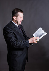 Middle aged solid tutor with book studio portrait.