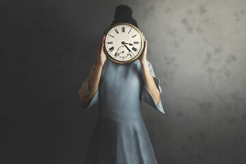 woman holds a clock in front of her face
