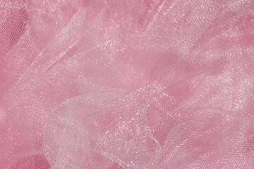 Pink tulle fabric texture top view. Coral background. Fashion color trends feminine tutu skirt flat lay, female blog backdrop for text signs desidgn. Girly abstract wallpaper, textile surface.