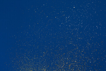 Gold glitter on blue background. Holiday abstract texture