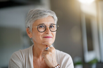 Portrait of a attractive smiling 55-year-old woman with white hair