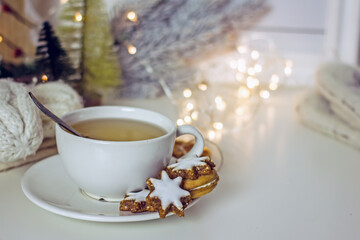 Homemade christmas star cookies on wooden tray beside  tea cup