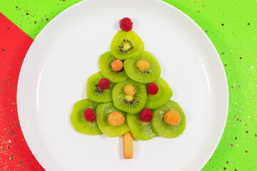 Christmas tree made of kiwi slices on winter color table.