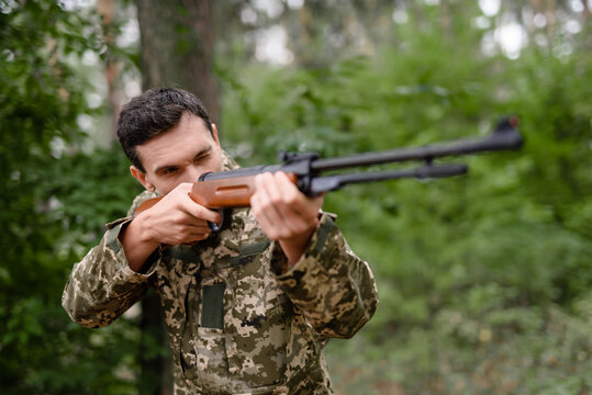 Shooter is Taking Aim with Rifle Hunt in Forest.