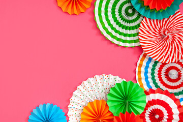 Colorful paper rosette and birthday garlands. Decorating for a party. Round, bright and color decoration. Pink background.