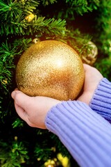 Girl decorates Christmas tree with toys