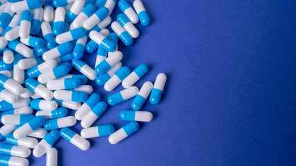 White and blue pills on a blue background. medical background