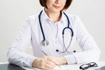 Close up female doctor hands writing on paper