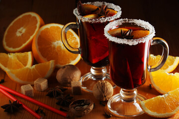 Two cups with ready mulled wine with anise, cinnamon and nuts around