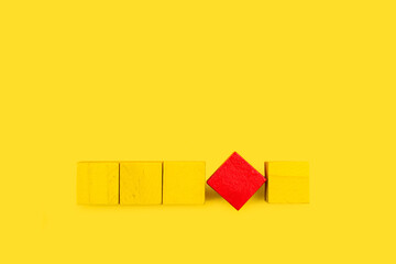 Cubos amarillos y cubo rojo sobre un fondo amarillo liso y aislado. Vista superior. Copy space - obrazy, fototapety, plakaty
