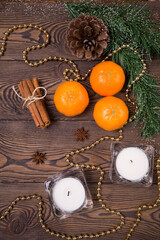 Fototapeta na wymiar Christmas background - fir branches with cones, tangerines with cinnamon, star anise, candles, Christmas decor. Flat lay, empty space