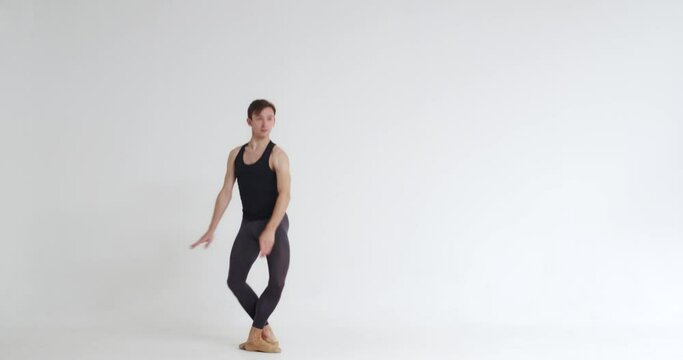 Elegant male ballet dancer performs acrobatic elements of a ballet dance on a white background, 4k slow motion.