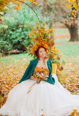 Obraz na płótnie Canvas Lovely bride in a white dress with a colorful bouquet and a wreath of leaves on her head outdoors in autumn