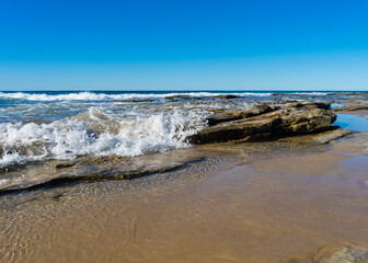 Wave breaking on a rock on a summer day