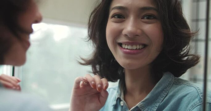 beautiful young smiling girl with short curly hair looking into the mirror confidently with self appreciation and self trust pretty young Asian woman looking at camera smile through 