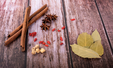 Exotic herbal Food concept Mix of the organic Spices cinnamon stick, cardamom pods, bay leaves, star anise on wood background