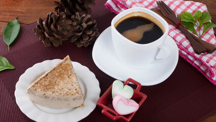 A glass cup of black coffee with cake on a background