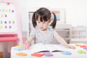 young  girl practice writing letters for homeschooling
